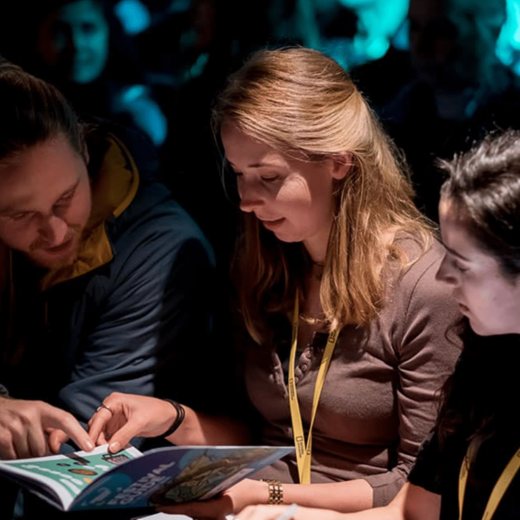 Delegates look at a printed programme at Wildscreen Festival